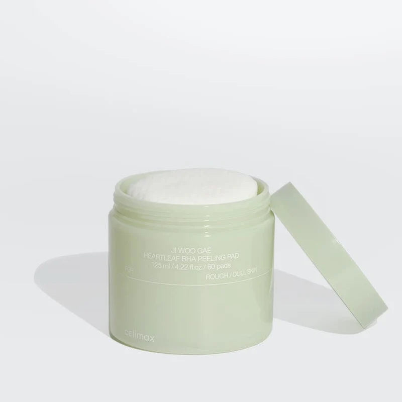 Green jar of cream with a white lid on a light gray background