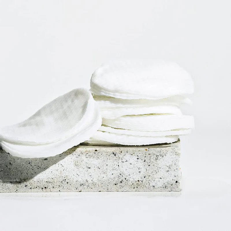 Stack of white napkins on a textured stone block with a white background