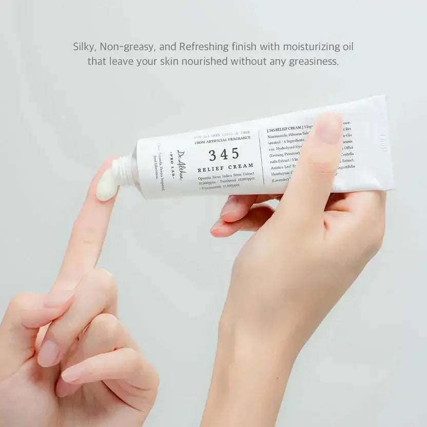 Hand holding a tube of Dr. Althea 345 Relief Cream against a light gray background