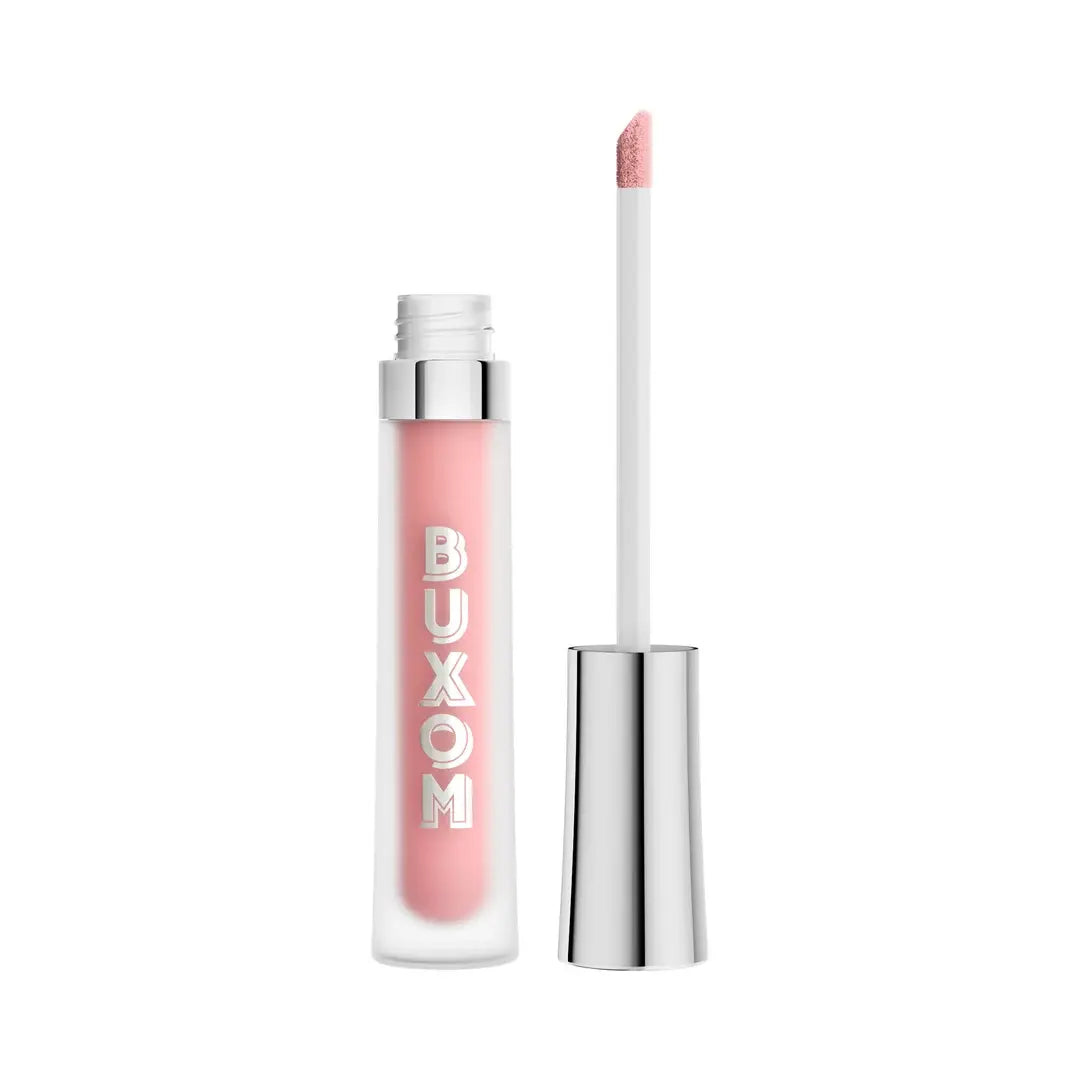 BUXOM lip gloss in a clear tube showing a soft pink color, with the cap removed and the applicator wand standing beside it on a white background.