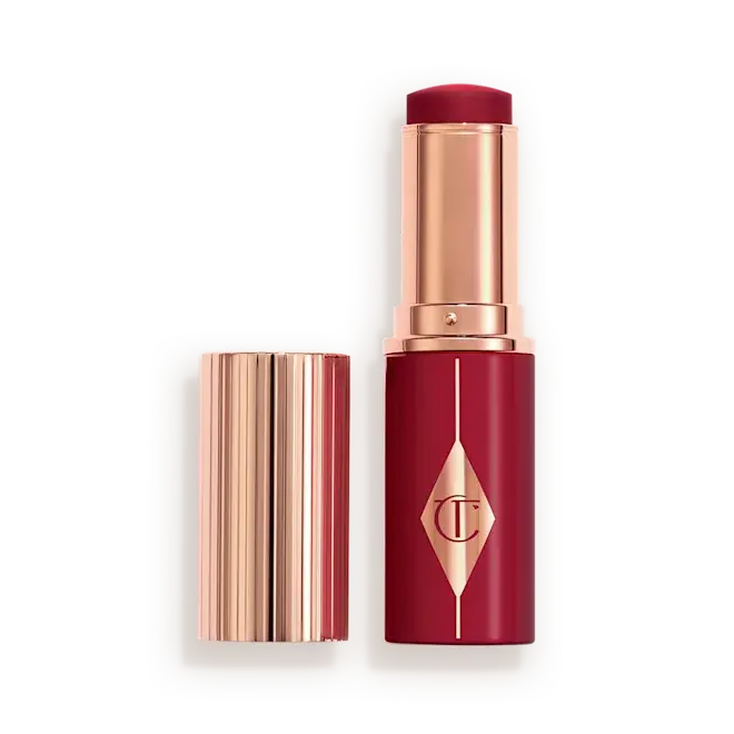 Berry Glow Blush Stick of Charlotte Tilbury with its cap off, showing the deep berry red lipstick bullet and metallic rose gold casing, displayed next to the cap on a clean white background.