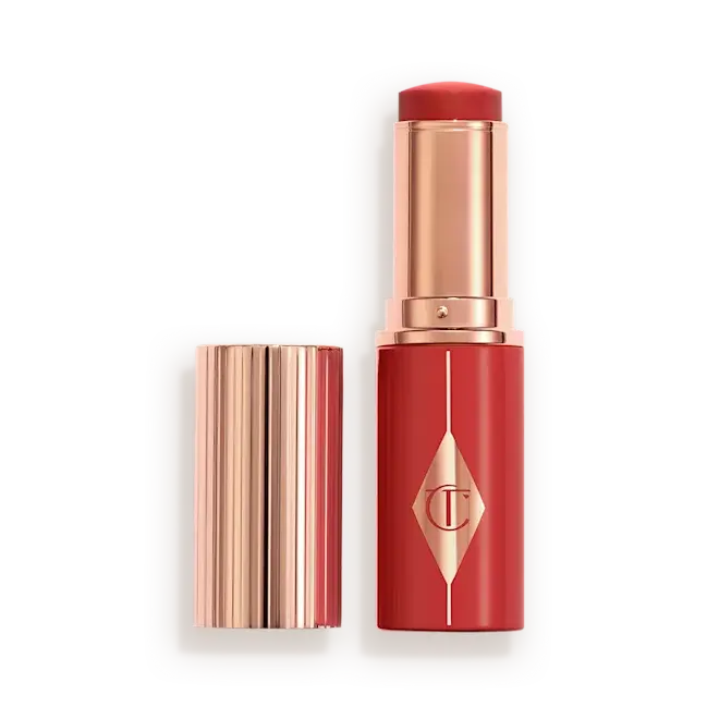 Cherry Glow Blush Stick of Charlotte Tilburywith its cap removed, displayed next to the lipstick bullet on a clean white background.