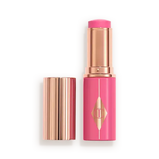 A Pinky Glow Blush Stick of Charlotte Tilbury, shown open with the cap beside it on a clean white background. 