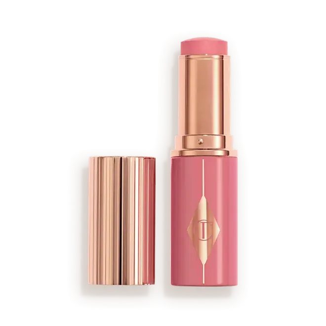 Rosy Glow Blush Stick of Charlotte Tilbury lipstick with its cap removed, displayed on a clean white background.