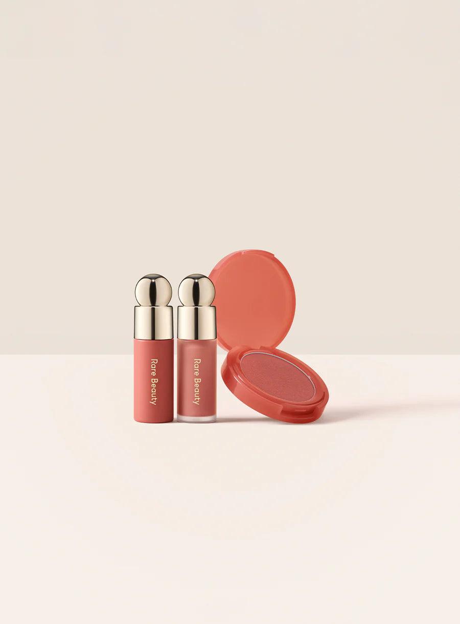 Rare Beauty Soft Pinch Cheek & Lip Trio Set Two lip products and a compact on a beige background