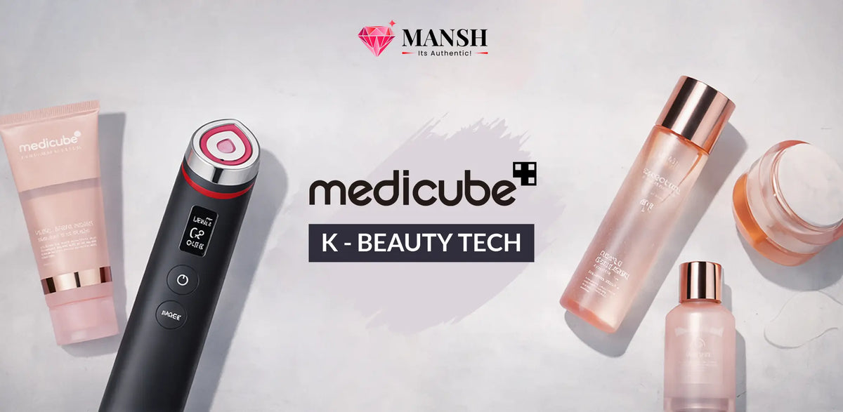 A promotional flat-lay featuring multiple Mansh medicube beauty tech products on a light gray textured background. The products include a black handheld beauty device with a red and white circular head, a pink squeeze tube, a tall clear bottle with a rose gold cap, a small jar, and a small bottle.