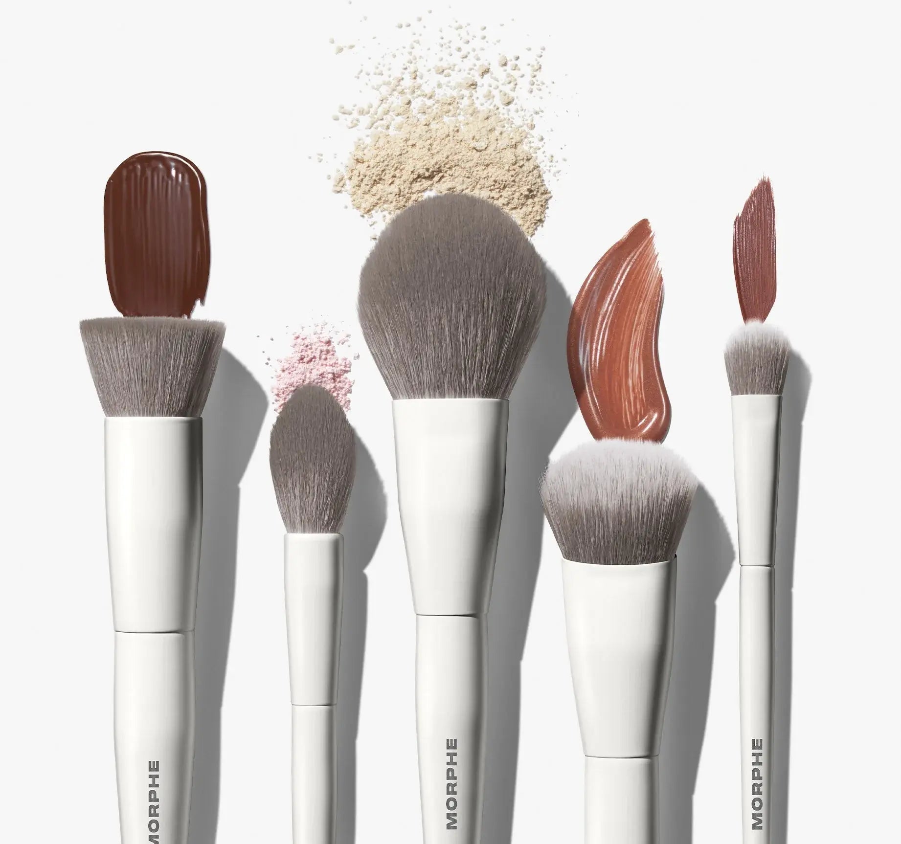 Set of Morphe makeup brushes with pigments on a white background
