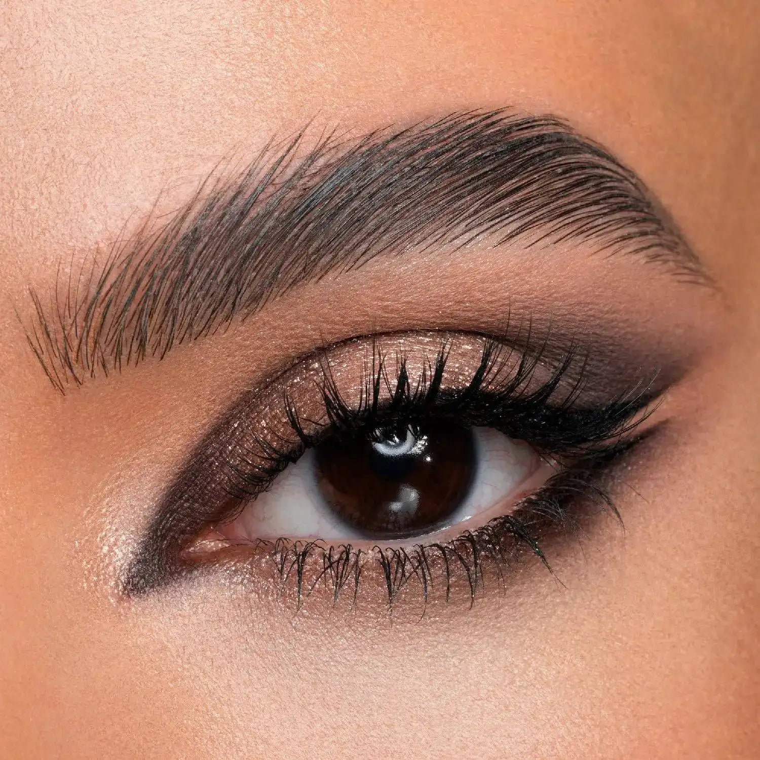 Close-up of a model's eye with Natasha Denona I need a Nude Palette makeup, focusing on the eyelashes and eyebrow.