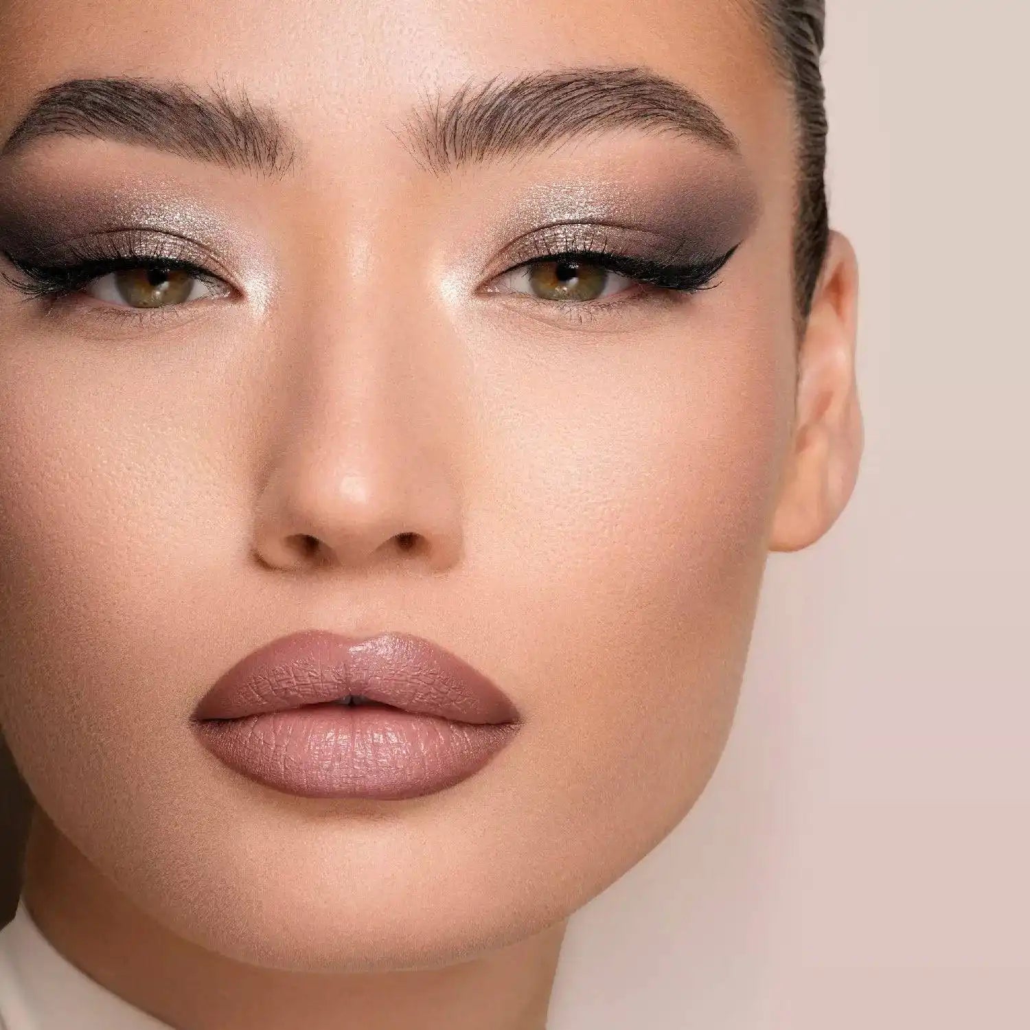 Close-up of a model's face with Natasha Denona I need a Nude Palette makeup on a neutral background