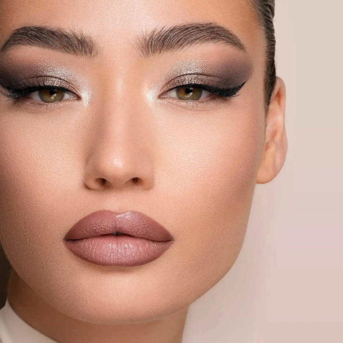 Close-up of a model's face with Natasha Denona I need a Nude Palette makeup on a neutral background
